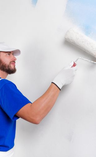 schilder doet met de kwast de muur schilderen